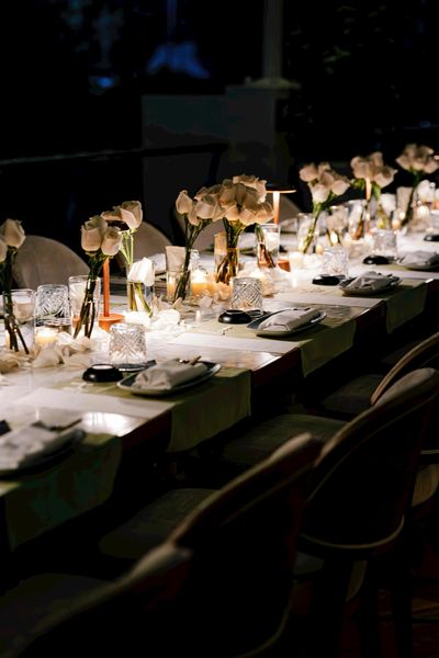 Close-up of a candlelit table setting with roses